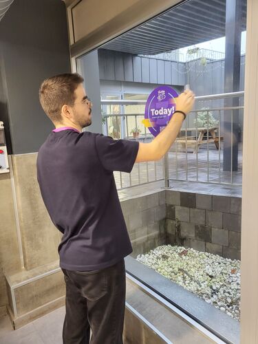 Pablo putting a poster about the ShuttleCon in the Empathy.co office